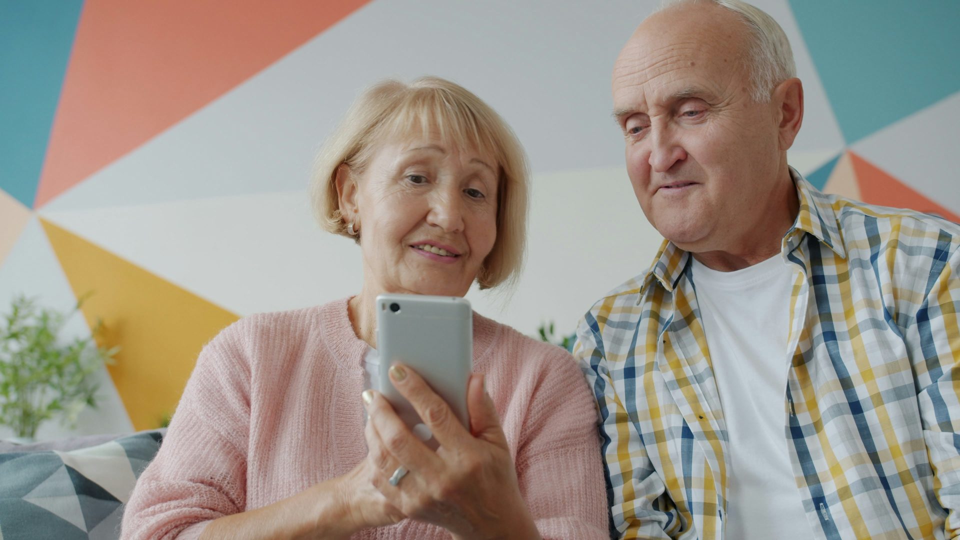A man and woman sitting down looking at a mobile phone